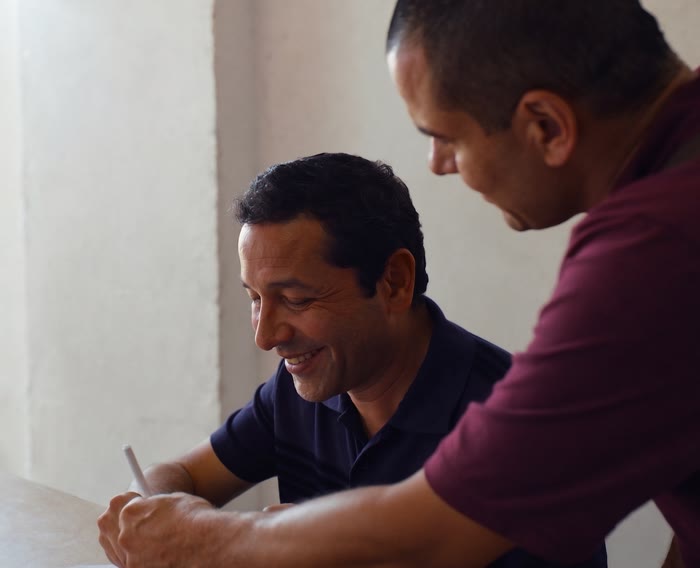 Imagen ilustrativa: un asesor acompaña a un emprendedor mientras revisa y firma sus documentos