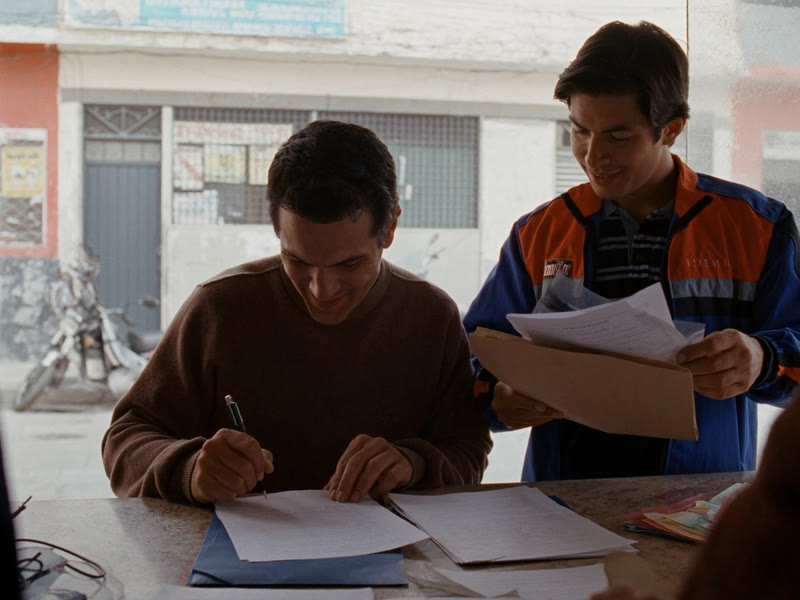 Imagen ilustrativa: un cliente firma sus documentos en su propio local mientras el mensajero espera con el sobre
