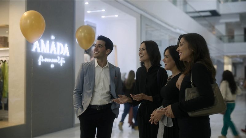 Imagen ilustrativa: socios celebran frente a su tienda; el nombre de su marca, AMADA, está iluminado en la entrada
