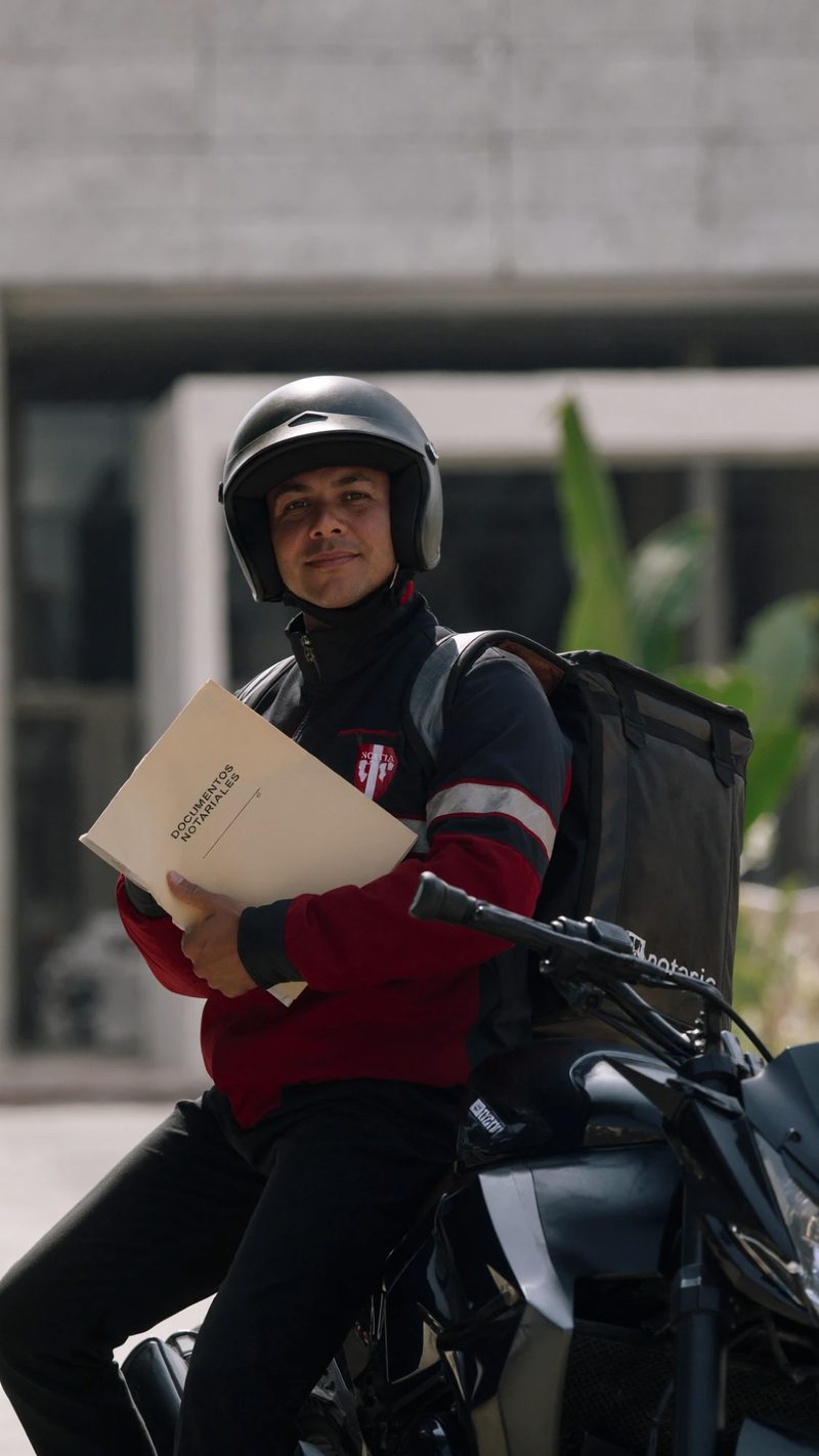 Imagen ilustrativa: el mensajero de la notaría llega en moto con la carpeta de documentos notariales